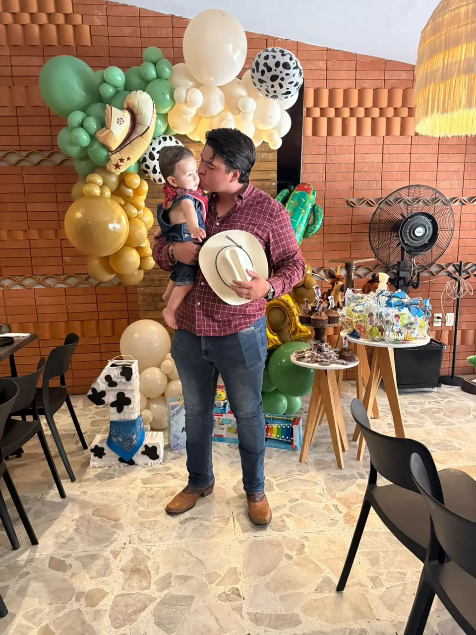 Papá besando a su bebé en su fiesta de cumpleaños
