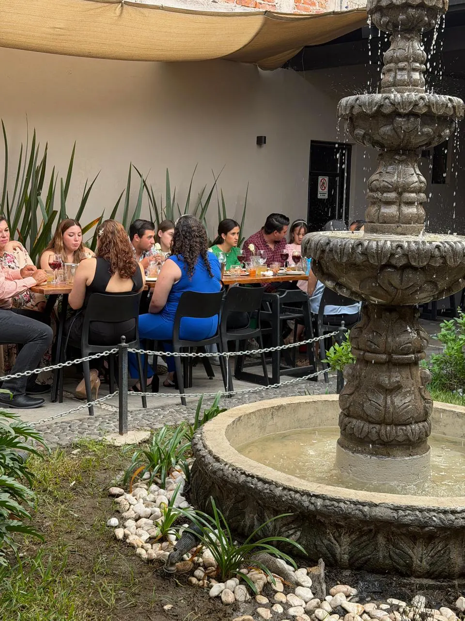 Invitados comiendo junto a la fuente del patio